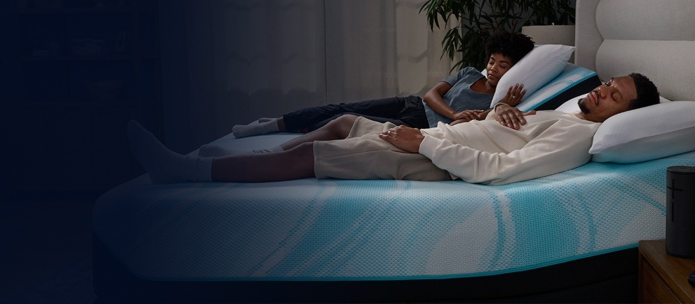 Couple sleeping on a LuxeBreeze Split Head King mattress fading into dark